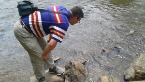 Dr. Campbell observes the river, finding several dead fish.