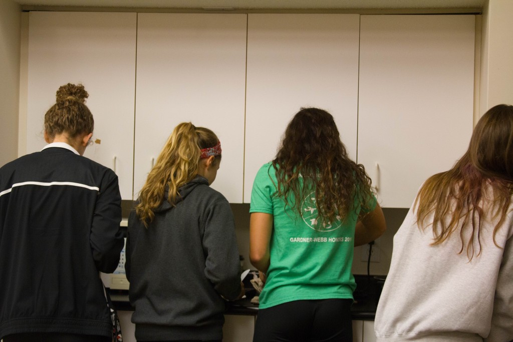 FCA leaders gather around skillets to cook pancakes for students who came.