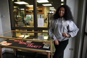Meachem stands with her display in the library. Photo by Elizabeth Banfield