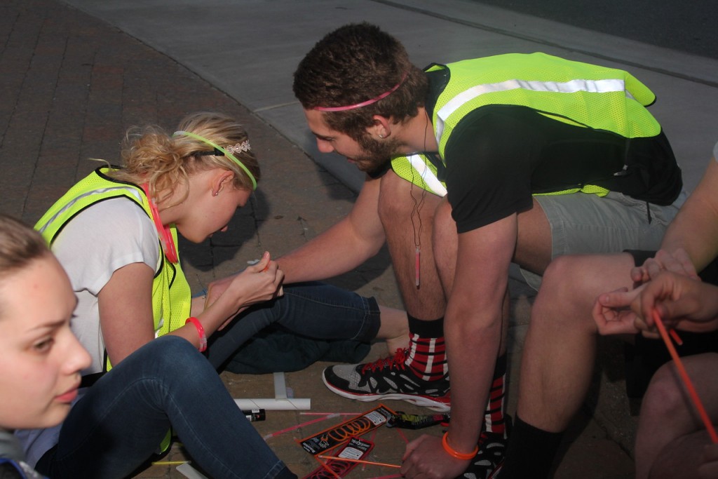 Carol Zangla helping Jake Ennis put on glow bracelets prior to the race.
