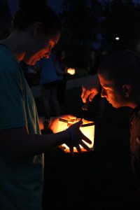 Micah Martin lights Taylor Schwartz's lantern for her. Photo by Elizabeth Banfield