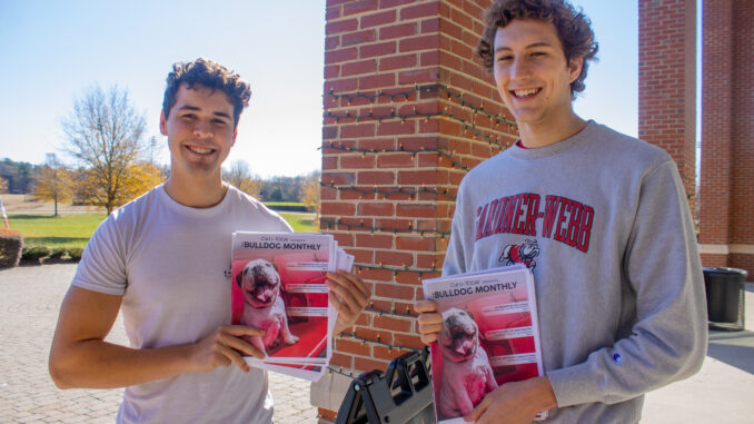 Students Paul McElearney and Theo Drescher hold up their copies of Bulldog Monthly Volume 0, Issue 1.